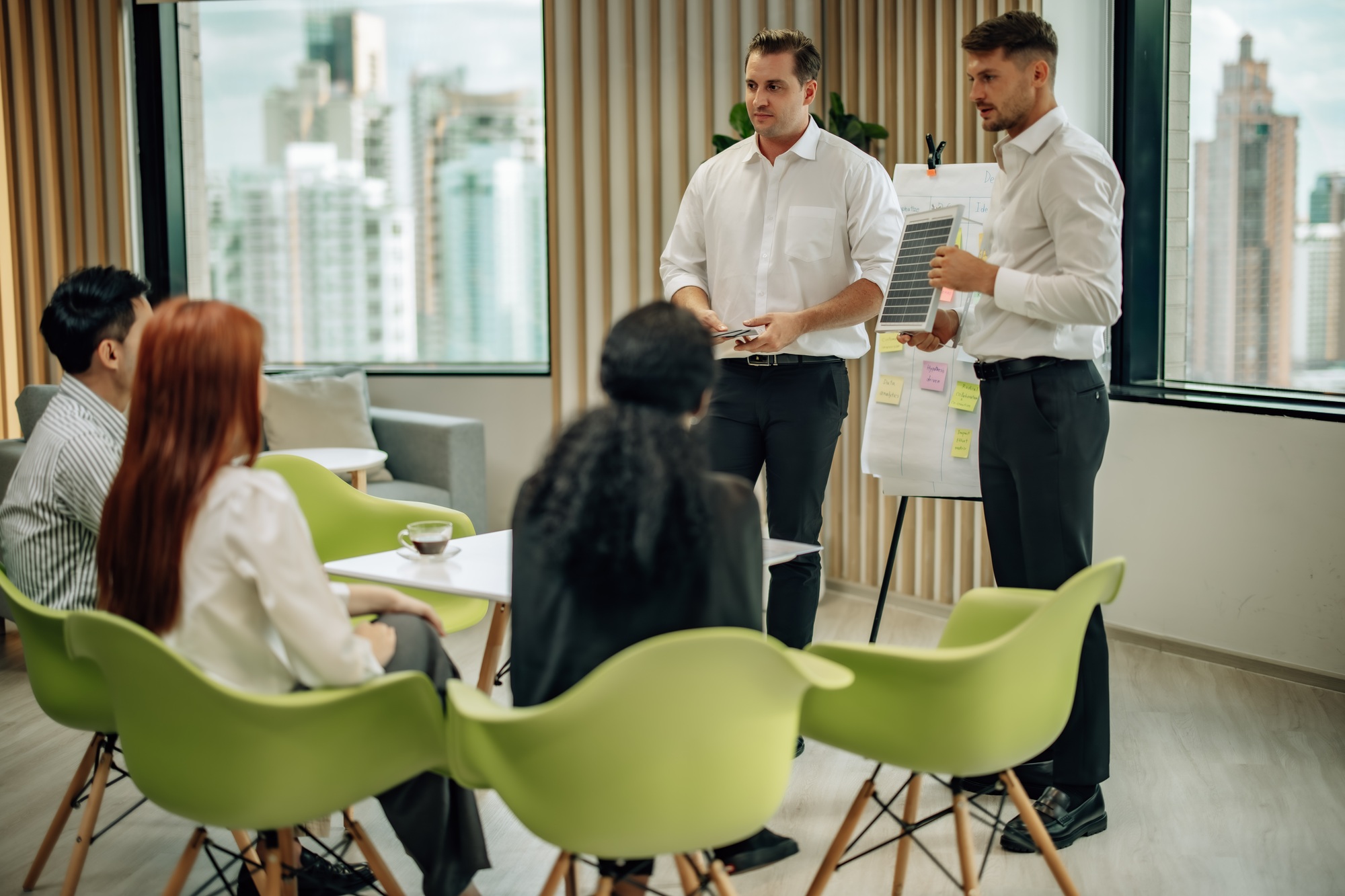 In diverse workspace, project manager presents eco-friendly solar panels, and sustainable solutions